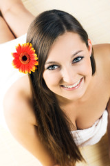 Fototapeta premium young smiling woman with a flower on her hair