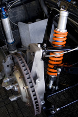 race car brake disk and orange shock absorber