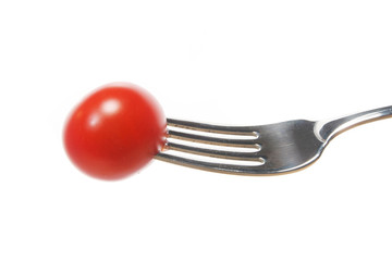 Red tomato on a fork isolated on white