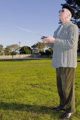Senior citizen playing with a small RC airoplane.