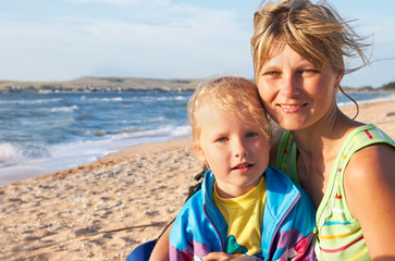 Fototapeta na wymiar mother with small daughter on sandy sea coast