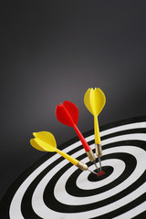 Portrait shot of three darts on bull's eye of a dart board