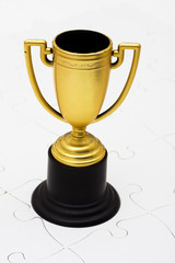 Trophy sitting on white puzzle, understanding how to be success