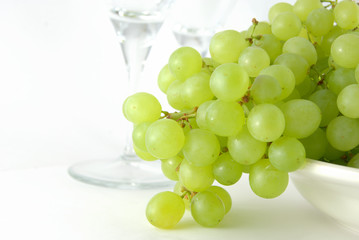 Bunch of green grape on the plate with two glass