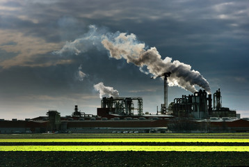 Industrial settlement smoke over moody sky. HDR image.