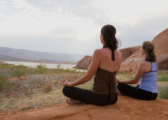 Fototapeta premium Yoga at sunset and two women