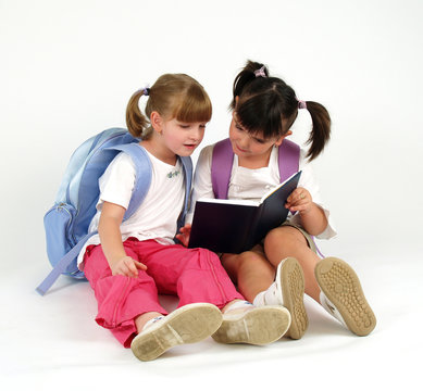 cute school girls looking in notebook