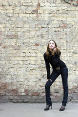 Girl posing near grungy wall