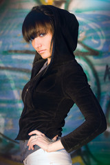 Handsome stylish brunette posing against graffiti wall