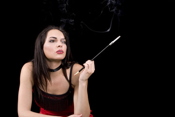 Attractive brunette woman smoking a cigarette through