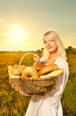 Beautiful young woman with a basket full of fresh bread
