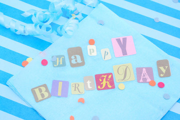 Happy birthday cut out letters on blue napkin