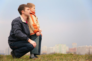 father and son on grass. city