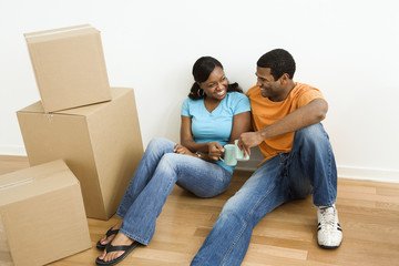 Black couple with moving boxes.