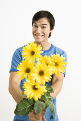 Smiling man holding bouquet.