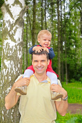 son sits on shoulders at  father