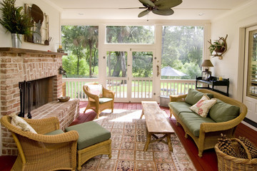 screen porch with fireplace and wicker furniture