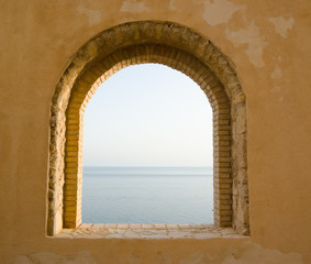 arched window of bricks on the sea.