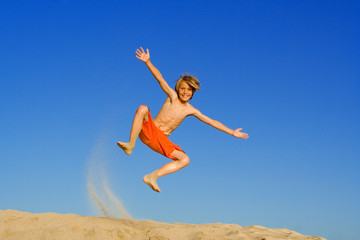 happy child jumping on beach vacation