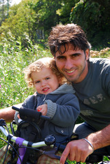 Papa à vélo avec son fils.