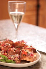 Tasty Bruschetta on a Plate With a Glass of White Wine