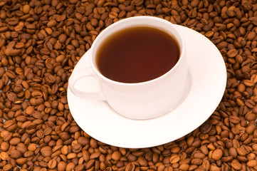White cup on the background of coffee beans