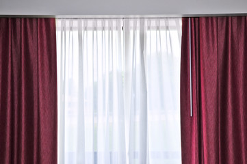 Large window with red and white drapes