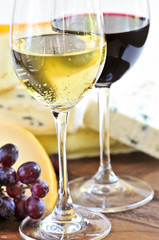 Wineglasses with red and white wine and assorted cheeses © Elenathewise