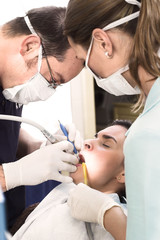 Obraz na płótnie Canvas Young female patient takes a dental attendance
