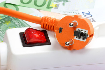 Stecker mit Stromschalter und Geldscheinen