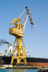Fototapeta na wymiar Yellow crane and ship in harbour or dry dock