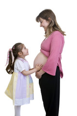 A young girl listens to her new baby siter in her mommy's tummy.