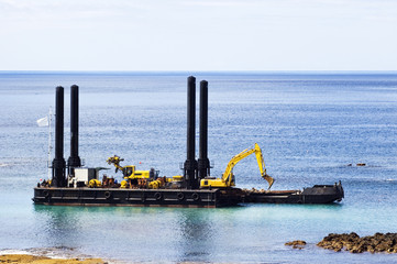 Dredger near the shore cleaning the bay