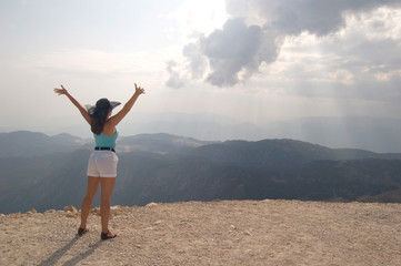 Attractive woman reaching hands to the sun