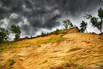 Sand bluff and storm clouds