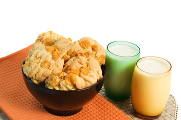 Freshly baked cookies and glasses of milk over white background