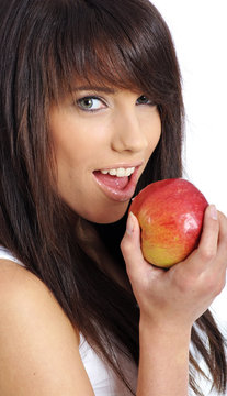 Beautiful young woman eating apple. Isolated over white