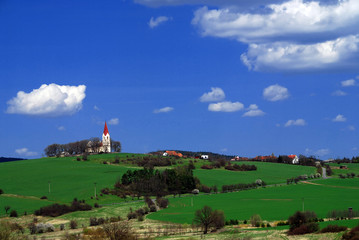 Fototapeta na wymiar Rural landscape with green fields, village and blue sky