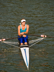 Sporty young lady rowing in boat on water © Anton Hlushchenko