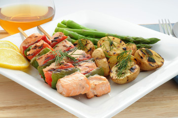 Grilled salmon with fresh vegetables on a skewer.