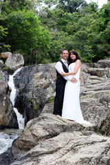 Fototapeta na wymiar Happy bride and groom standing on top of a mountain.