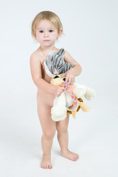 little naked girl is staing with a toys