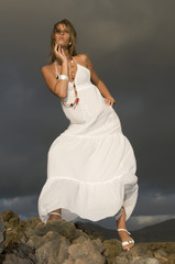 Fototapeta na wymiar beautiful model under a dark sky with white dress