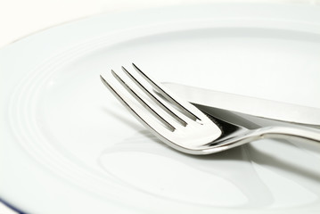 a fork and knife on a plate close-up shot.
