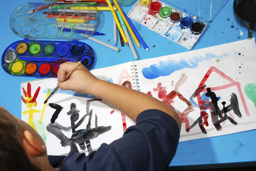 A young boy draws a picture