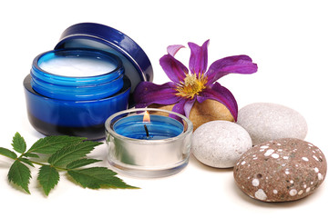 blue cosmetic cream,rebble, candle, flower on white