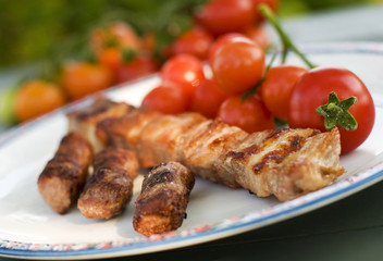 grilled meat with tomato on a plate close up