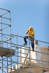 Fototapeta na wymiar Pracownicy budowlani na rusztowaniach