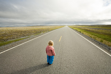 little girl standing at the beginning of road going to horizon - 9184214