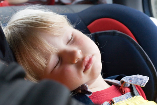 little child sleeping in the car